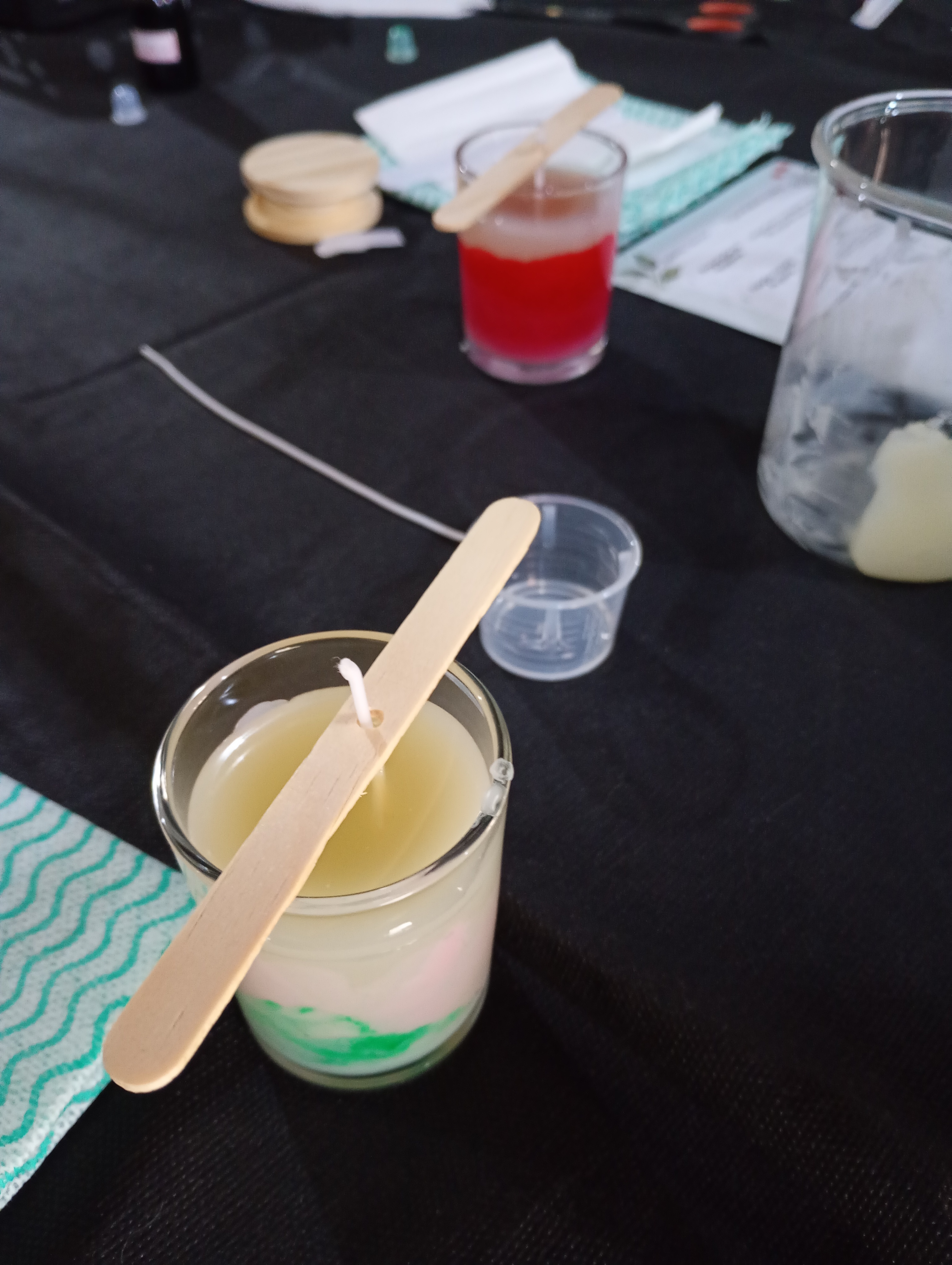 Mãos de diferentes mulheres fazendo crochê juntas ao redor de uma mesa de madeira com novelos, agulhas e xícaras, energia criativa coletiva em ambiente acolhedor