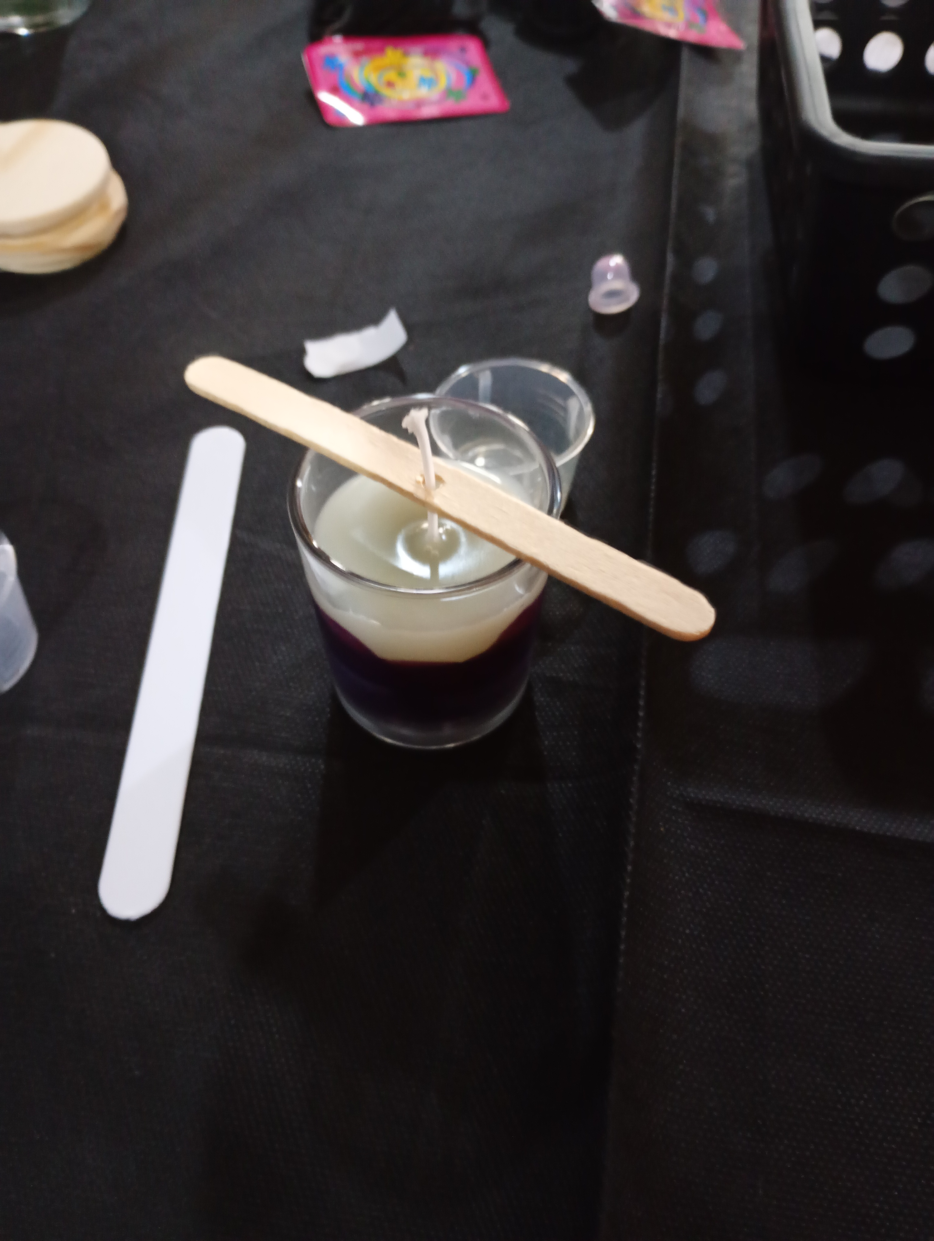 Mãos femininas segurando agulha de crochê e novelo de lã em tons neutros, com iluminação suave de ambiente acolhedor ao fundo desfocado