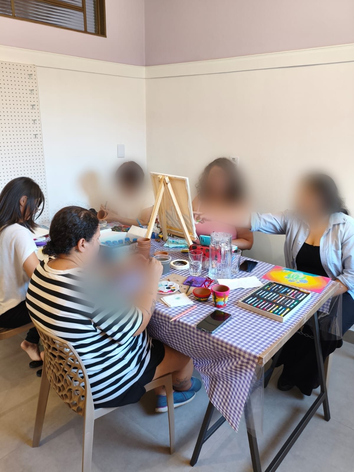 Participantes pintando telas em aquarela e giz pastel durante a oficina Pincelando do Respiro Criativo